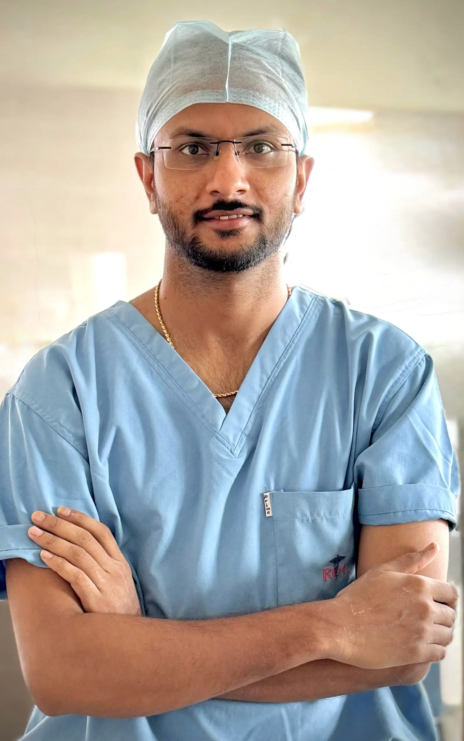 Tall portrait of Dr. Balagangadhara Choudhary V in surgical scrubs